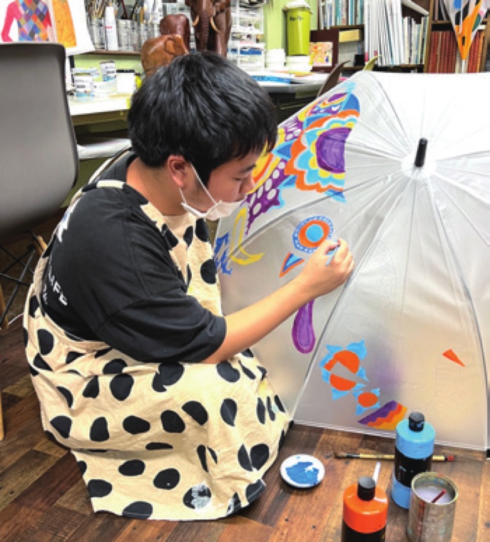 イラスト傘に絵付けをする利用者